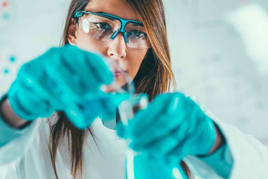 female scientist testing chemical purity of industrial lubricant